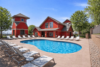 Resort style swimming pool with lounge chairs and clubhouse